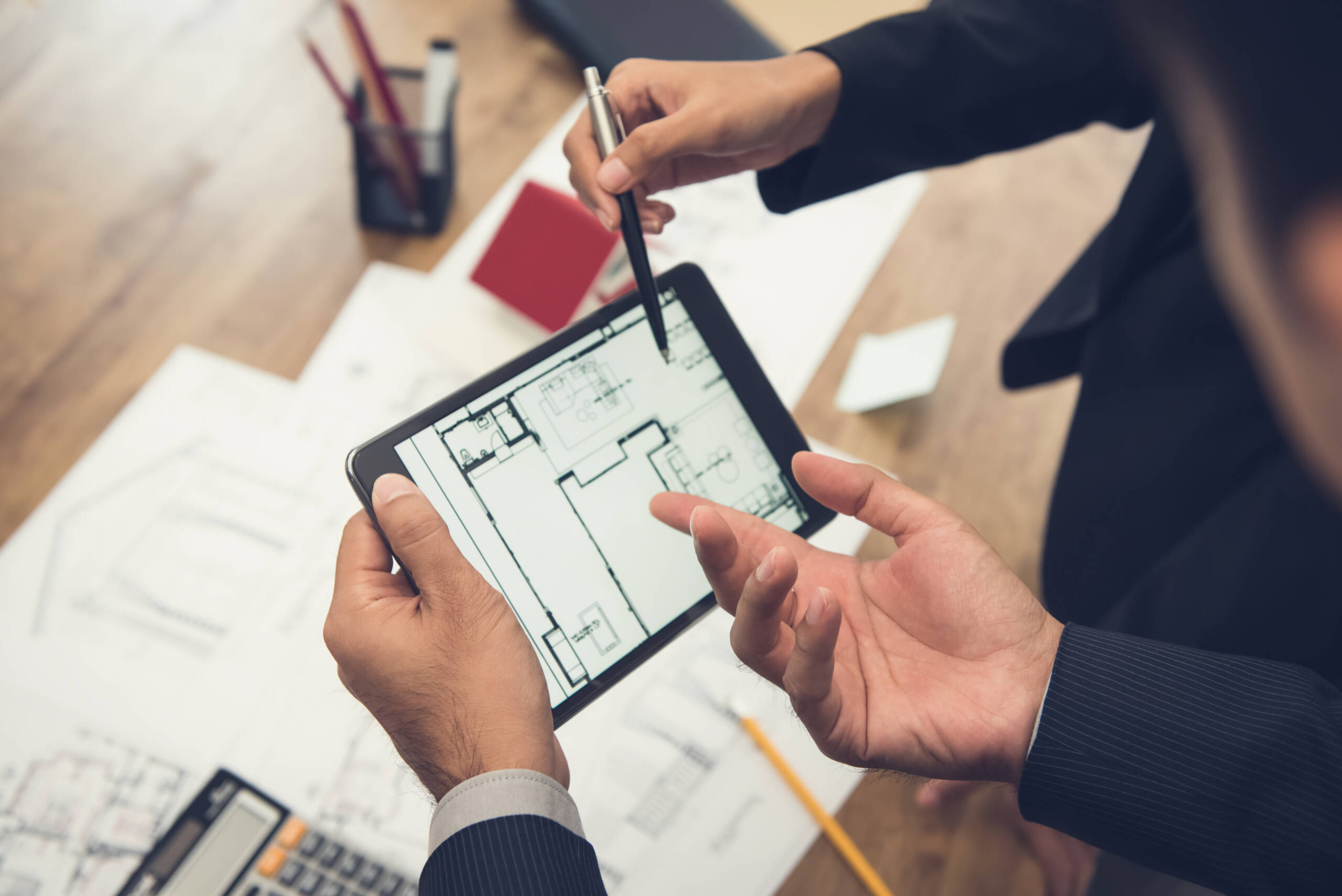 Two mortgage brokers look over a new builds plans on a tablet